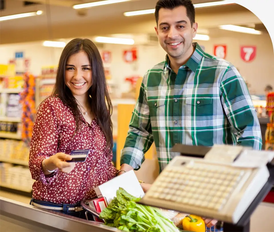 A man and woman standing at the checkout counter.