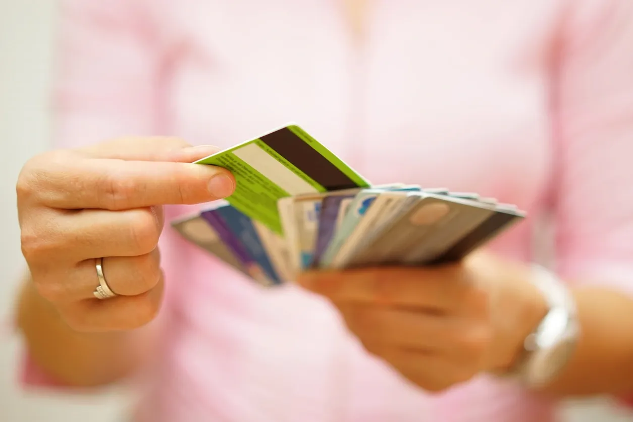 A person holding up several credit cards.